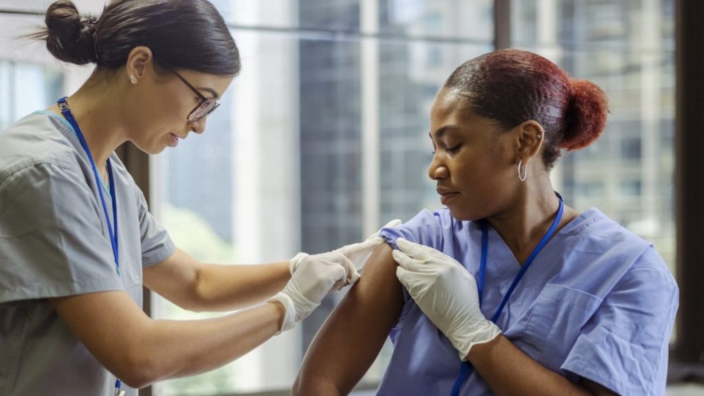 A nurse giving a vaccination to a patient in a clinic.