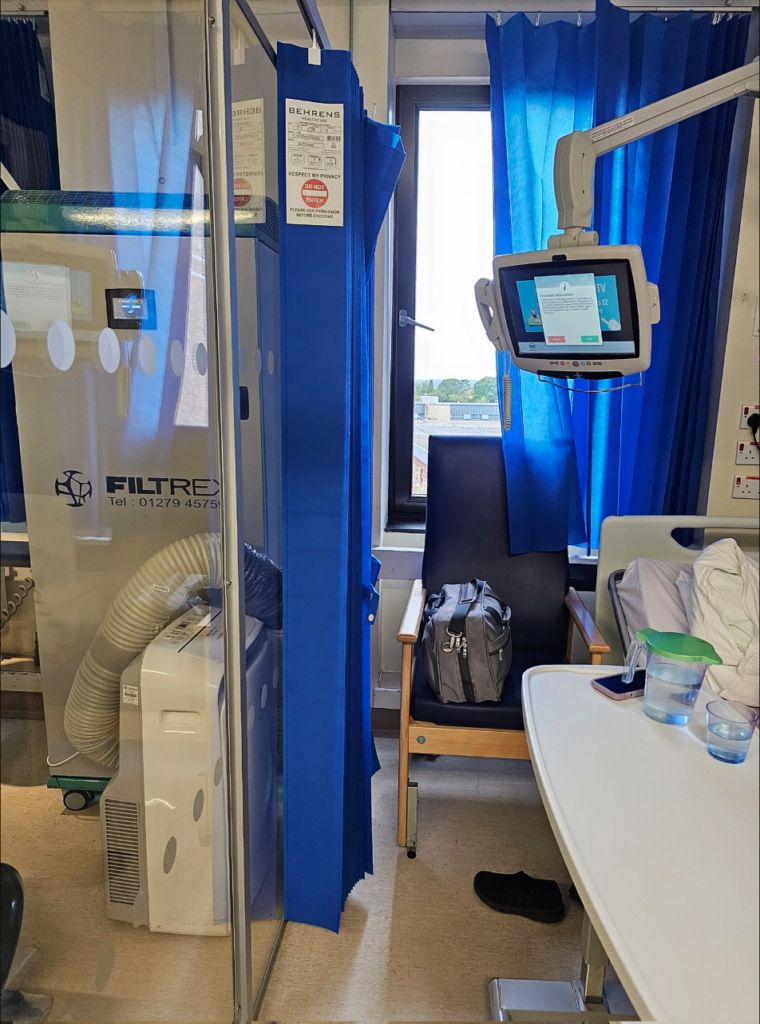 A hospital side room with a portable HEPA air filter unit.