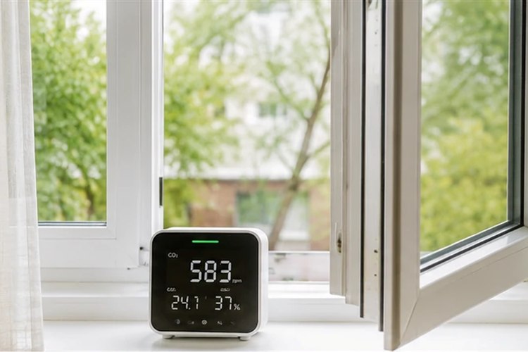 An open window beside a CO₂ monitor showing 583 ppm.